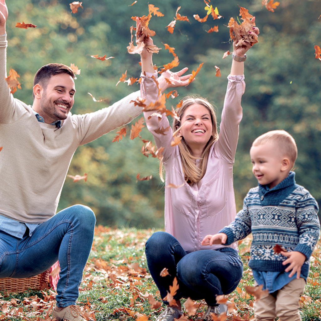 Famille qui joue dans les feuilles